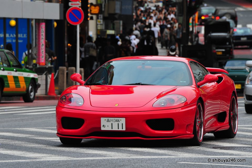 Red Ferrari rolls through the Shibuya Streets.