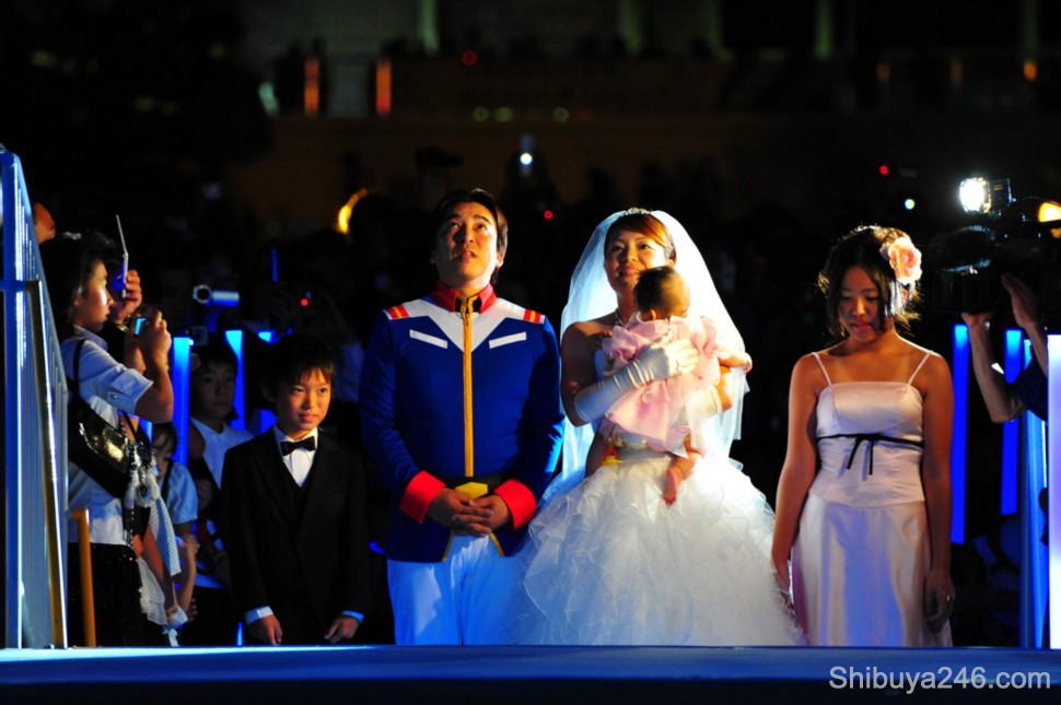The ceremony begins with the couple climbing the steps up to Gundam's boots
