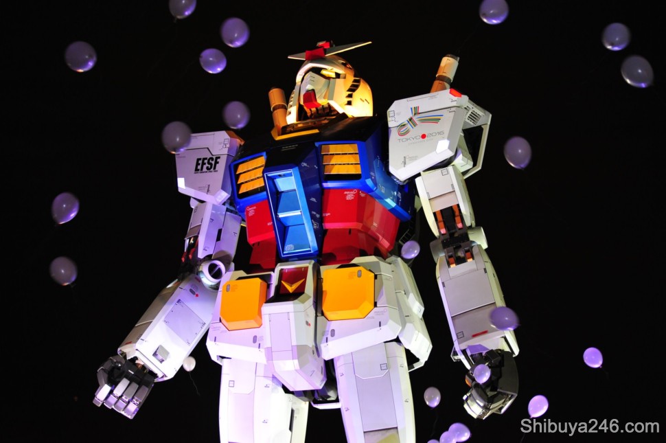 The balloons are released and float past Gundam