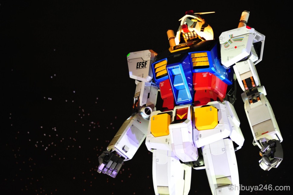 As the balloons float off into the distance, Gundam stands watch