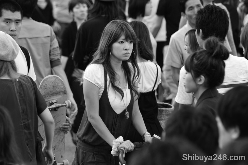 A mother takes a moment of reflection as she pushes her pram through the crowds. What type of fashion will her child claim for the next generation of Shibuya young