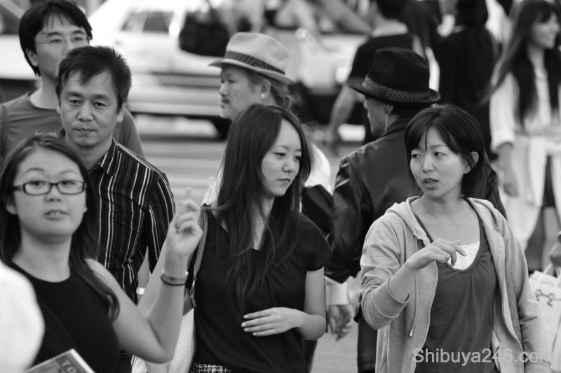 Some nice hats in the background here as friends cross the road talking