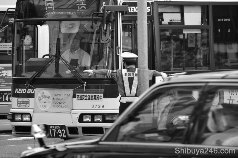 The bus is directed into its spot. Tokyo 2016 Olympic banners on the front