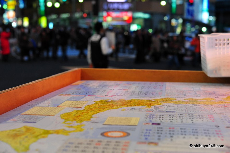 Heading into Bic Camera to look at some other digital cameras. Saw these free 2010 Japan map calendars out and decided to try a shot of them with a reflection of the crowd. Not quite what I was looking for, but interesting nonetheless (Nikkor 60mm)