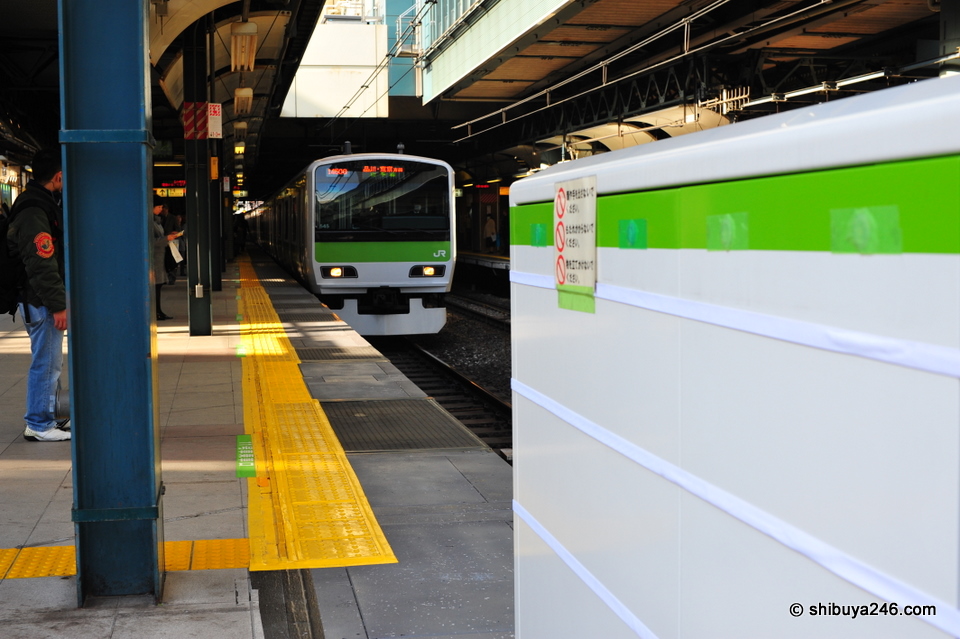 Looking back at the Yamanote Line train as it approaches the platform and the test gate section.