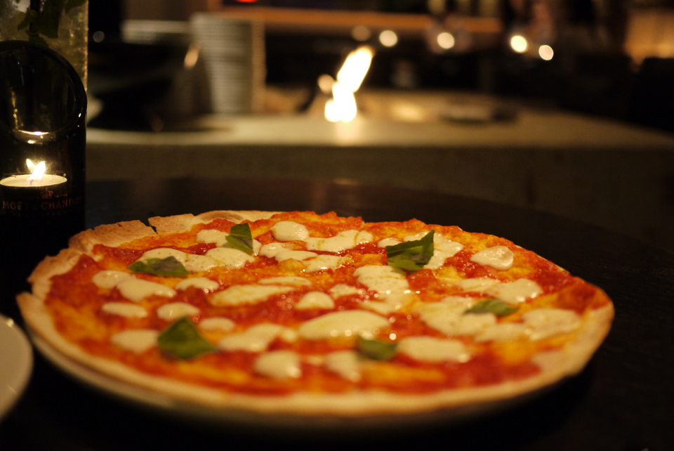 Margarita pizza with fireplace in the background